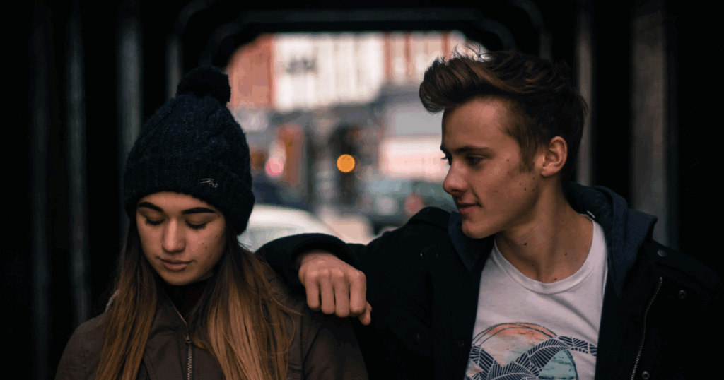 Sadistic Personality Disorder: A young man gazes at a somber young woman with a beanie, portraying complex human behavior.