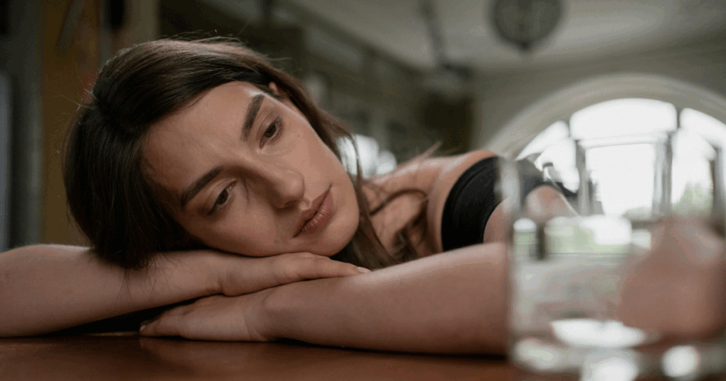 Woman resting head on arms, contemplating cognitive development, assimilation and accommodation concepts.